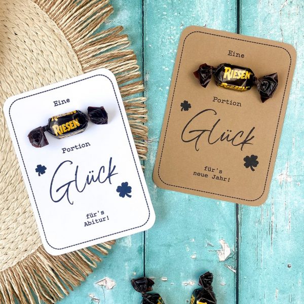 Zwei Karten mit aufgklebtem Riesen-Bonbon mit dem Text "Eine Riesen Portion Glück für's Abitur bzw. für's neue Jahr.