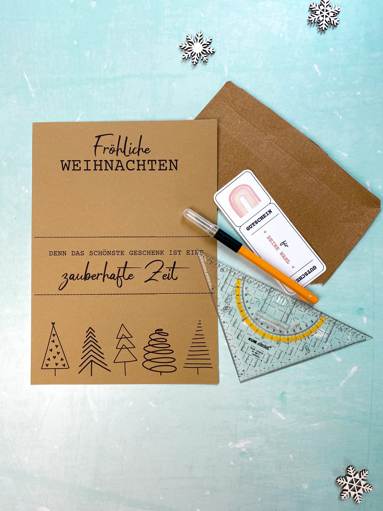 DIY Bastelmaterialien für ein Gutscheinposter mit Aufschrift „Fröhliche Weihnachten – Denn das schönste Geschenk ist eine zauberhafte Zeit“. Abgebildet: Kraftpapier, Gutschein, Stift und Schneidewerkzeug. Gutschein verpacken Weihnachten mit PDF Druckvorlage zum selber machen.