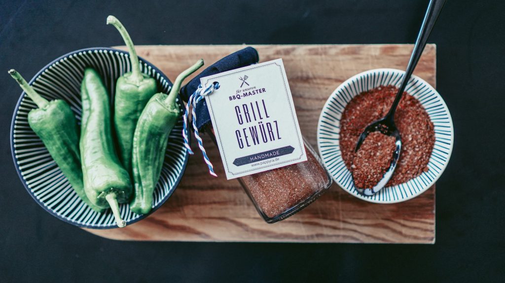 DIY-Grillgewürz als Geschenk zum Grillen auf Holzbrett angerichtet. Würzige Grillen-Geschenkidee mit selbst gemachtem Gewürz für echte BBQ-Liebhaber.