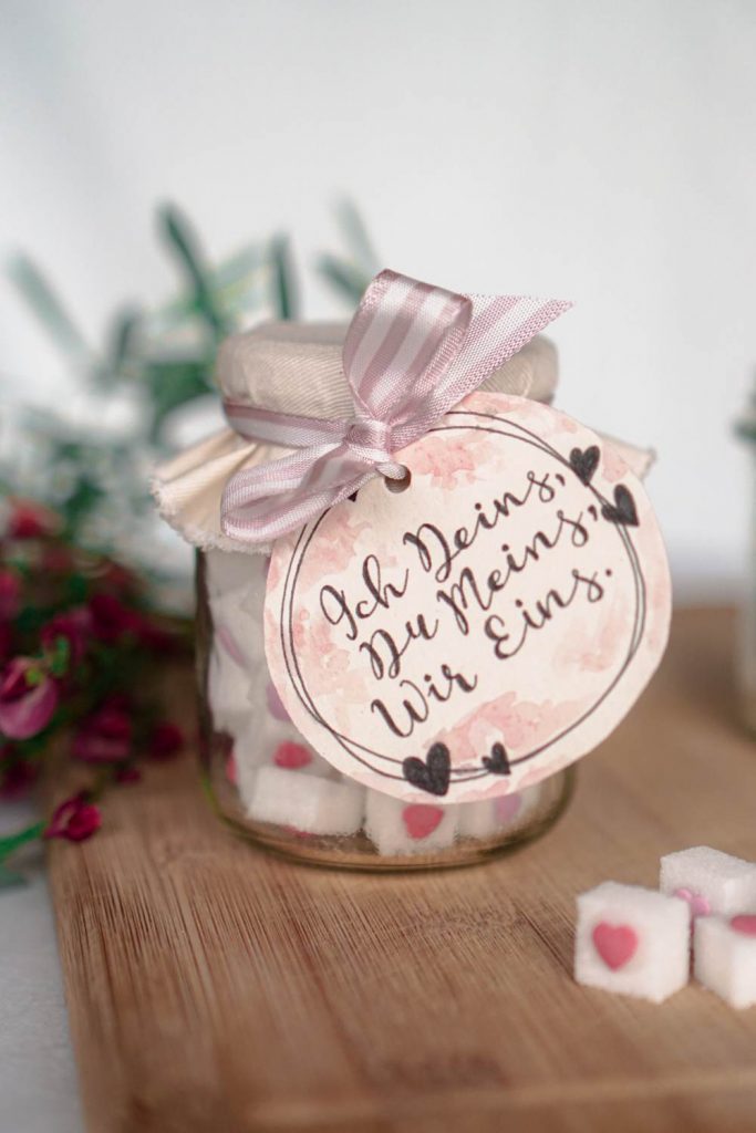 Selbstgemachtes kleines Geschenk zur Hochzeit: Zuckerwürfel mit Zuckerherz und romantischem Etikett zum Ausdrucken im Glas verpackt.