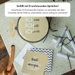 Blick von oben in das Motivation Geschenk: Ein Deckel mit der Aufschrift "Ich kann Ich will Ich werde" und danebenliegende gerollte Papierlose.