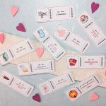 Ausgeschnittene romantische Valentinstag Gutschein Vorlagen, die dekorativ auf einem hellen Hintergrund mit kleinen Papierherzen verteilt sind. Die Karten zeigen verschiedene Date-Ideen wie Kinonacht und gemeinsames Sonnenuntergang-Anschauen.