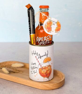 Eine kreative Aperol Geschenkidee zum Geburtstag. Eine upgecycelte Konservendose, verziert mit der digitalen Druckvorlage "Holy Aperoly", ist befüllt mit einer kleinen Flasche Aperol Spritz und Schokolade – ideal als schnelles DIY Geschenk und Last Minute Geschenk.