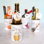 Eine vielseitige Bier Geburtstag Geschenkidee: Verschiedene upgecycelte Konservendosen, verziert mit digitalen Druckvorlagen, dienen als dekorative Halterungen für eine Bierflasche, Sekt und Aperol samt Snacks. Eine kreative PDF Vorlage für ein liebevolles DIY Last Minute Geschenk.