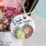 Detailaufnahme eines runden Geschenkanhängers mit der Aufschrift 'Danke für alles!' und zwei kuschelnden Avocados – eine süße Ergänzung für dein Beste Mama Muttertag Upcyling Danke Last Minute Geschenk zum Selbermachen.