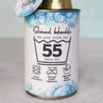 Eine gestochen scharfe Nahaufnahme der Konservendosen Banderole. Man sieht deutlich die Zahl 55, den witzigen Spruch "Schonend behandeln" und humorvolle Waschsymbole vor einem blauen Seifenblasen-Hintergrund. Diese detailreiche PDF Vorlage wertet jedes DIY Geschenk zum runden Geburtstag auf. Greife auf digitale Druckvorlagen zurück, um ein beeindruckendes Last Minute Geschenk zu zaubern.