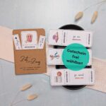 Personalisierter Gutschein handgemacht: fertig gebastelte Gutscheinkarte mit eingestecktem Kinogutschein, daneben liegen drei weitere Gutscheinoptionen (Massage, Restaurant, Bowlen) als Symbol für flexible Kombinationsmöglichkeiten und Zeit statt Zeug Geschenke.